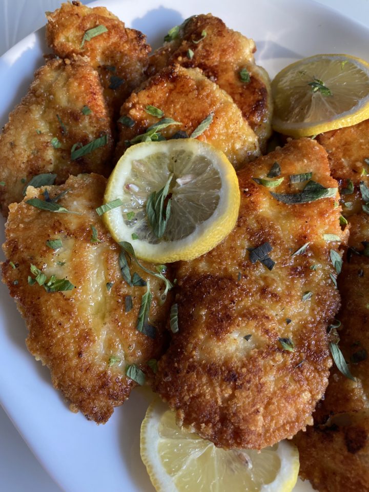 parmesan crusted chicken breasts in lemon butter garlic sauce plated